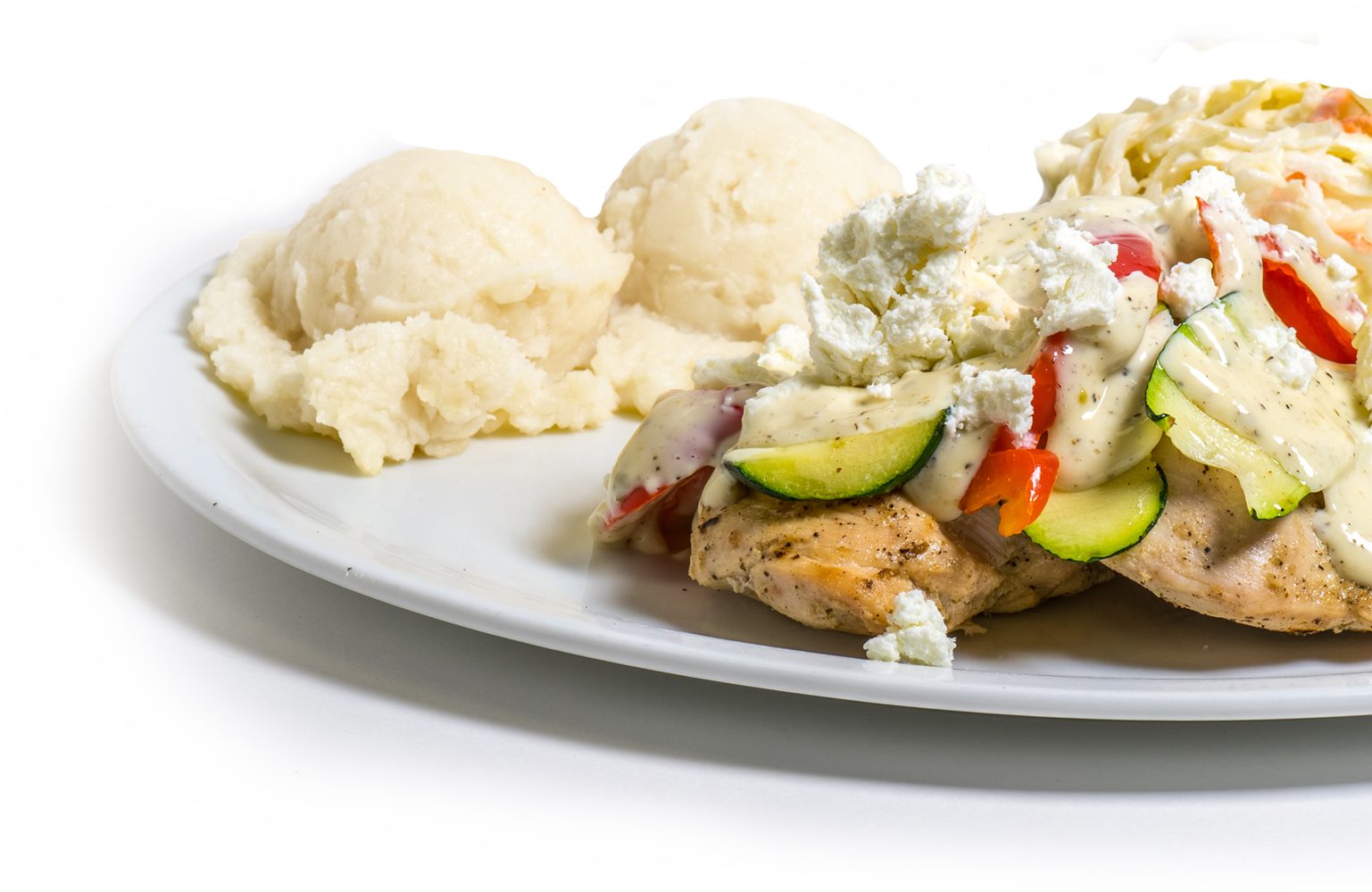 Grilled chicken on pita topped with feta and vegetables, with mashed potatoes